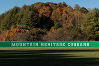 Thumbnail for Green printed baseball outfield fence windscreen with Mountain Heritage Cougars team branding along outfield fence