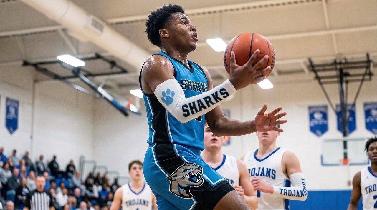 Basketball player in a teal Sharks uniform going for a layup in a white custom arm sleeve