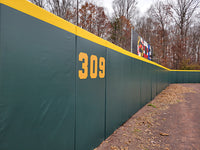 Thumbnail for Green and gold stadium outfield wall padding at Prince George's Stadium showing custom distance markers and protective padding for minor league baseball