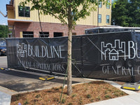 Thumbnail for Black mesh construction fence screen printed with the Buildline General Contractors logo on temporary fence panels in front of a building under construction.