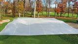 FieldSaver golf course green cover from CoverSports protecting a putting green in late fall, with fall foliage and fairway visible in the background