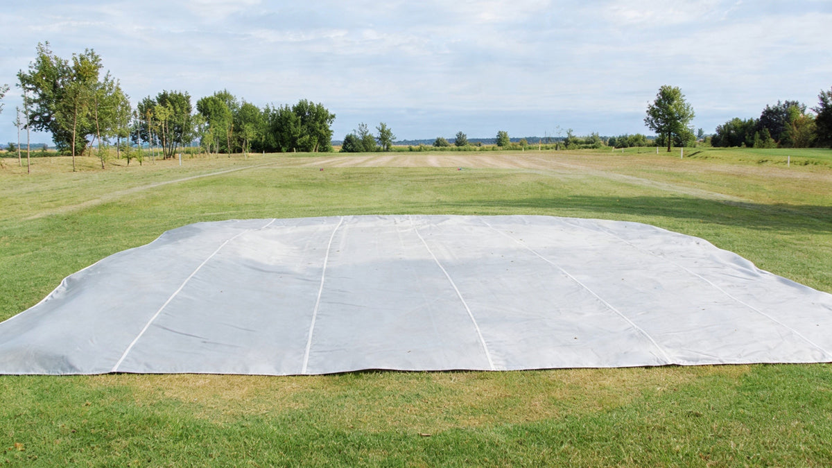 IeldSaver golf course cover from CoverSports protecting a rectangular tee box at a golf course, showing how polypropylene covers shield greens and tee boxes from winter weather