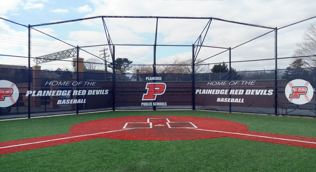 Custom printed backstop windscreen hanging from batting cage