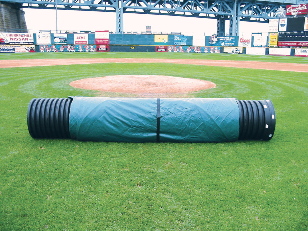 Green field tarp wrapped on a black corrugated roller tube on a baseball infield near the pitcher's mound