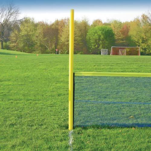Yellow foul pole beside black outfield fencing with a yellow top rail on a grass field