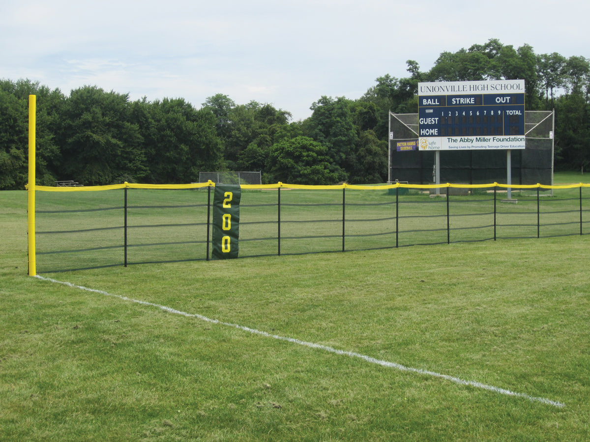 Black outfield fence with a yellow top rail, yellow foul pole and green 200 marker by a Unionville High School scoreboard