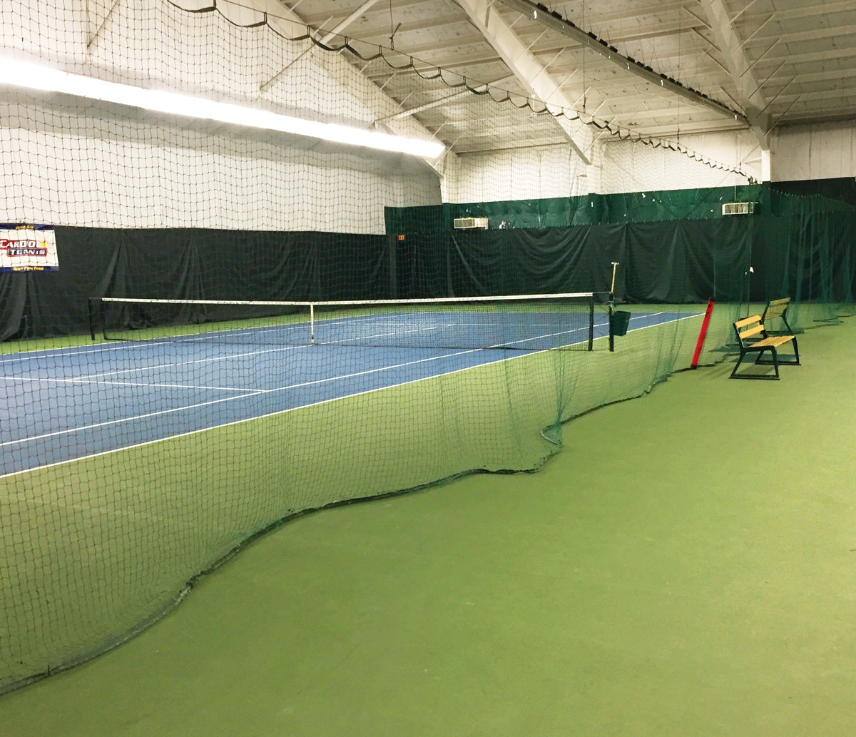 Indoor tennis divider netting separates two courts