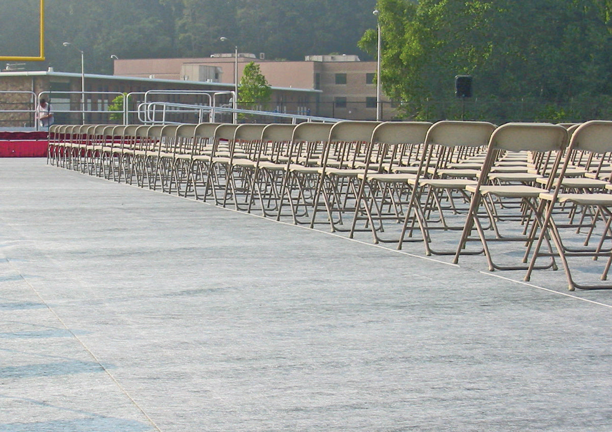Stadium turf protector covers beneath chairs at graduation