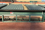 Green custom fence rail and post padding installed on a dugout rail at a baseball stadium