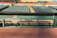 Thumbnail for Green custom fence rail and post padding installed on a dugout rail at a baseball stadium