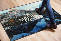 Thumbnail for Custom printed door mat with The North Face logo over a mountain lake scene on a wood floor