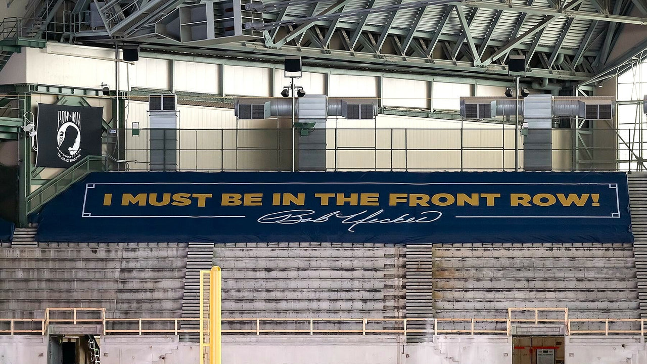 Custom printed stadium seat covers in navy blue with gold text covering bleacher sections at American Family Field