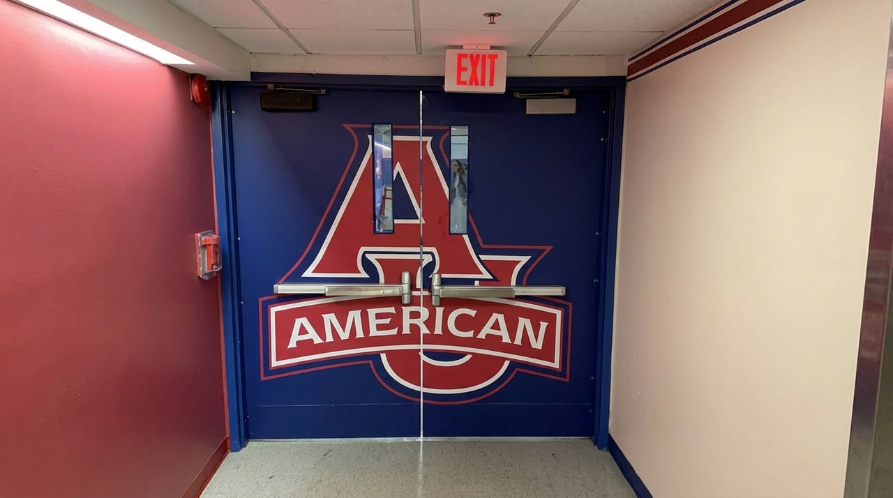 Navy double doors covered in a vinyl wrap with a red and white American A logo under an exit sign