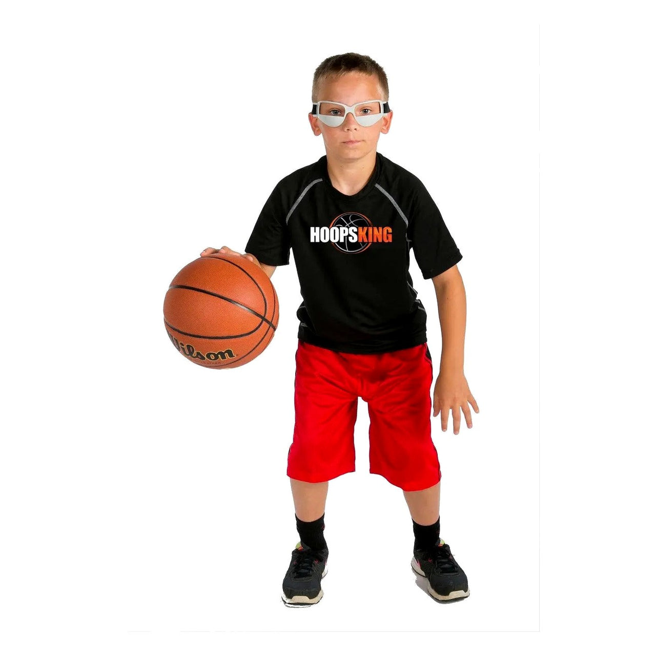 Young player in a HoopsKing shirt wearing dribble goggles and dribbling a basketball in a low stance