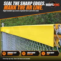 Thumbnail for Yellow Safety Top Cap molded cap snapped over the top rail of a chain-link fence in front of green trees