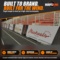 Thumbnail for Printed windscreens with sponsor logos including Michaels Bakery and McElroy Packaging along a stadium fence beside a track at night