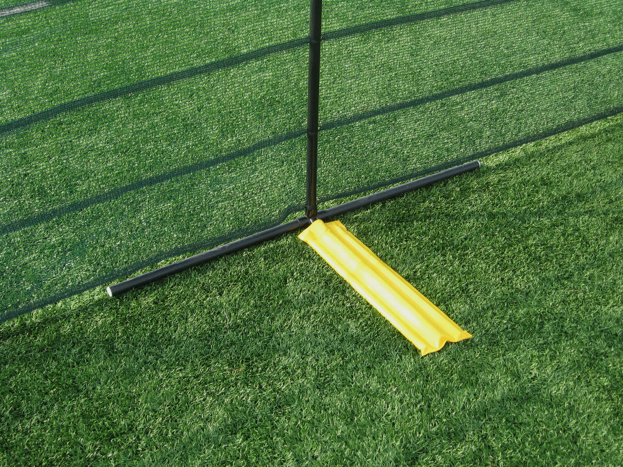 Weighted base of CoverSports Grand Slam above-ground portable outfield fencing installed on turf field for baseball and softball