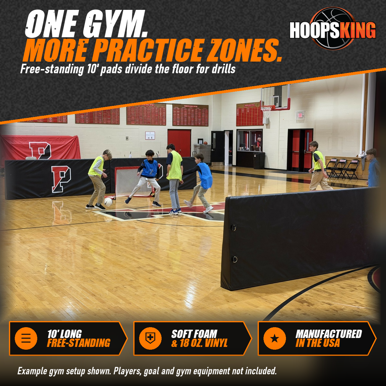Black free-standing barrier pads, some printed with a red P logo, dividing a school gym where kids play soccer