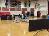 Protective barrier pads installed on indoor gym walls providing cushioned safety padding for basketball courts, volleyball facilities, and multipurpose athletic spaces