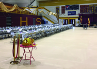 Thumbnail for Tan gym floor covering protecting basketball court during school banquet with draped tables and formal place settings
