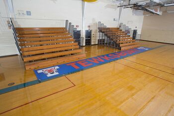 Custom-printed gym floor runner with a school name