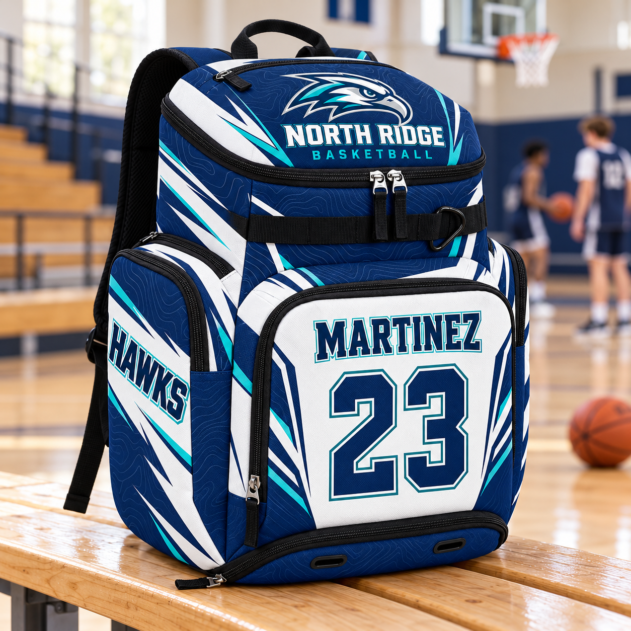 Custom basketball backpack in navy, white and teal with North Ridge Hawks artwork, Martinez 23 personalization, and separate ball and shoe compartments, shown courtside.