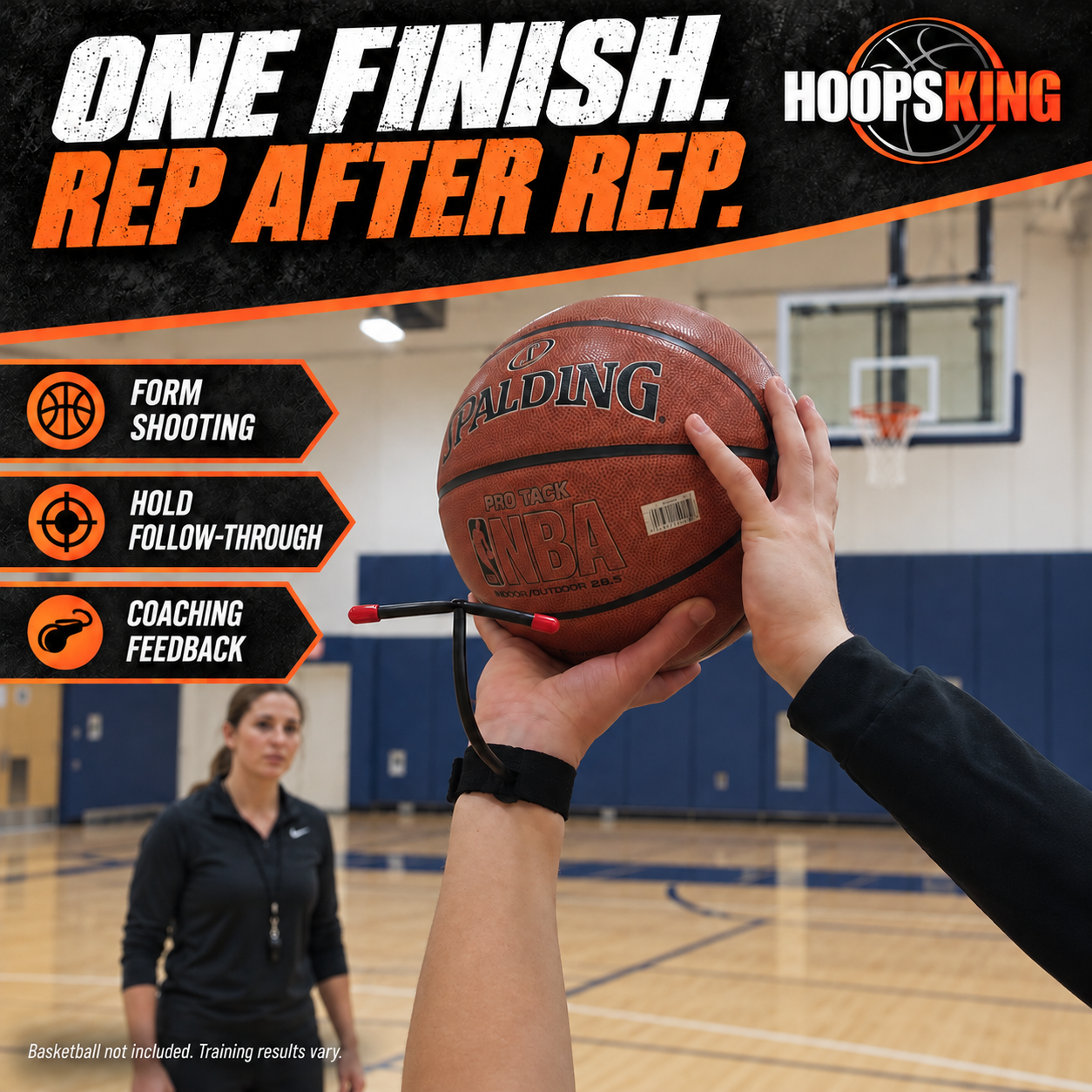 Close-up of hands holding a basketball with the MarksMan wrist-mounted shooting aid, while a coach observes form practice.