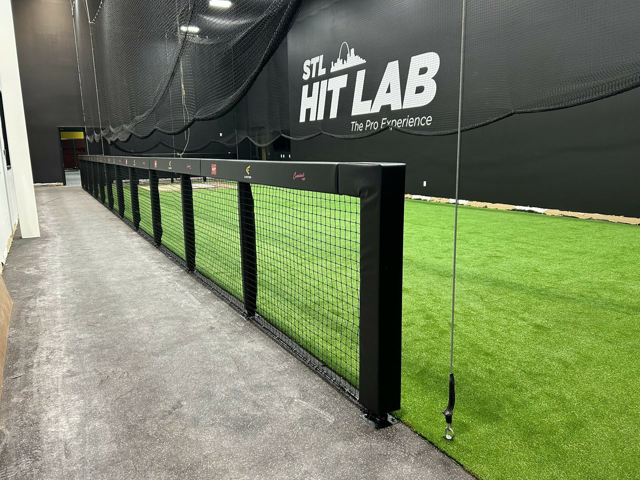 Xt Indoor batting cage kit with black custom rail padding and wall padding installed at STL Hit Lab training facility