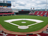 Thumbnail for White skin tarps covering the base paths and infield dirt of a baseball diamond, with round covers on the pitcher's mound and home plate in an empty ballpark