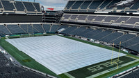 Thumbnail for Lincoln Financial Field stadium interior showing a CoverSports growth cover deployed across the Philadelphia Eagles NFL field between the end zones, with the Eagles logo visible on the seatback covers and the team name displayed on the sideline barrier