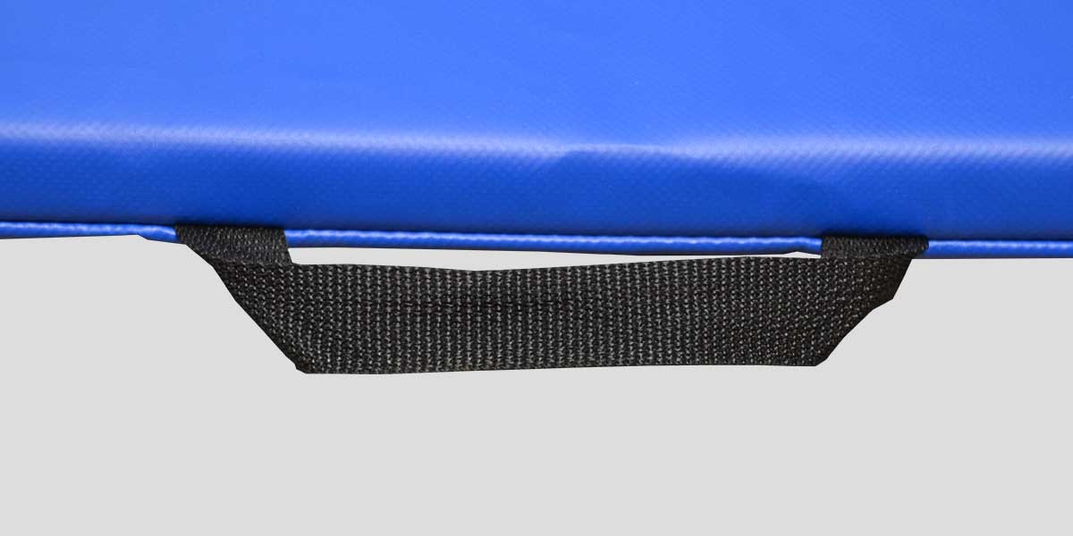 Close-up of a blue exercise mat with a black fabric carrying handle.