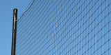 Black netting attached to a pole against a clear blue sky.
