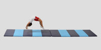 Thumbnail for Gymnast doing a backbend on a long, folding blue and gray polyethylene mat.