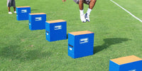 Thumbnail for Blue plyometric boxes with tan tops on a green field, a person jumping over them.