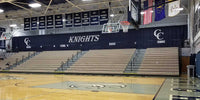 Thumbnail for Black gym divider curtain with "KNIGHTS" and "CC HOME" logos above empty bleachers in a basketball court.