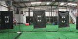 Three black baseball strike zone targets with white outlines and circles hanging in a batting cage.