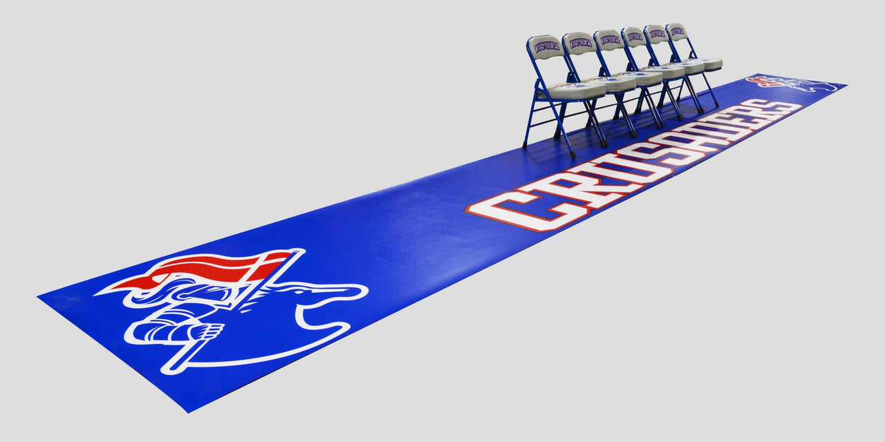 Blue mat with "CRUSHERS" text and a knight logo, with 5 folding chairs on top.
