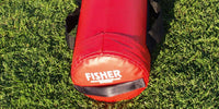Thumbnail for Red cylindrical football tackling dummy with "FISHER" logo on green grass.