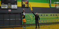 Thumbnail for Basketball player shooting a ball while a coach holds a yellow foam stick.