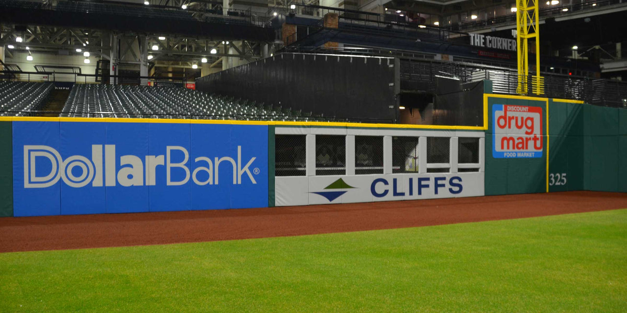 Blue and green wall panels with sponsor logos in a baseball stadium.