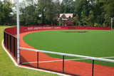 Red mesh baseball outfield fence windscreen on synthetic turf field at Saint Joseph's University Hawks