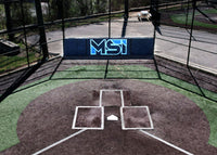 Thumbnail for Navy backstop padding with a light blue MSI logo behind home plate in an outdoor batting cage
