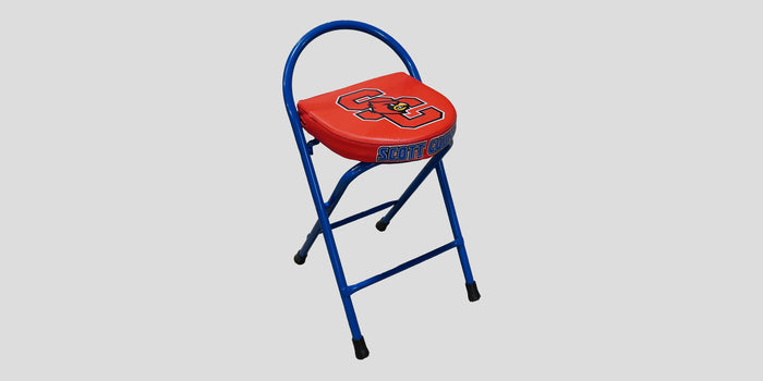 Blue folding stool with red padded seat and "SC" logo.