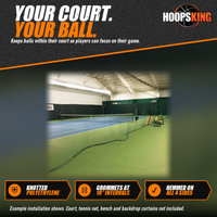 Thumbnail for Dark green knotted divider netting hanging between two indoor tennis courts, beside a bench on a green court surface