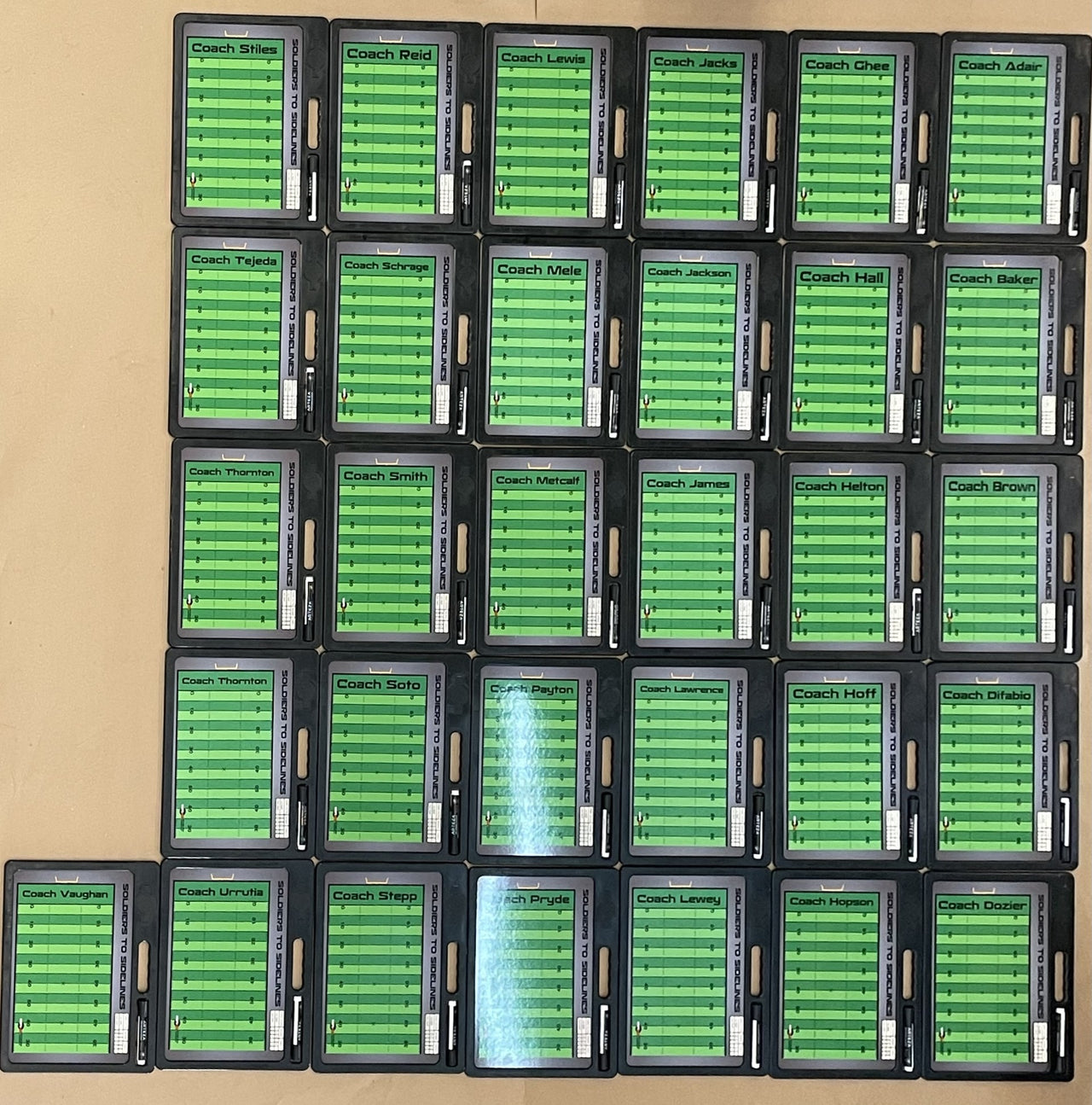 Grid of 35 custom football whiteboards, each with a green field, black border, and a coach's name.