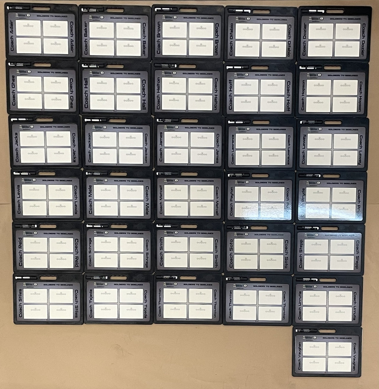 Grid of 35 custom pro football whiteboards with handles, each labeled with a different coach's name.