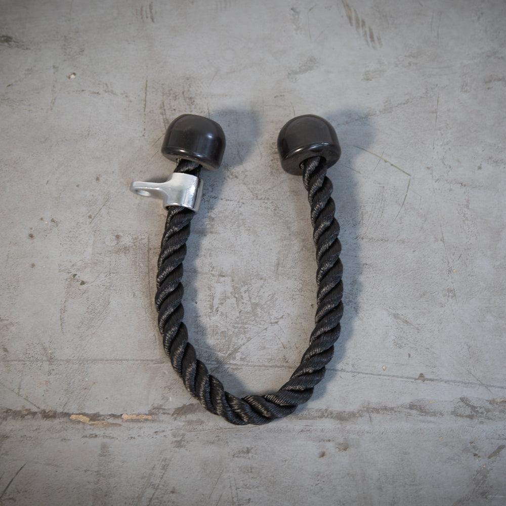 Black triceps rope with silver attachment and black rubber ends, on a gray concrete background.