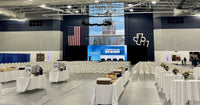 Thumbnail for Gray GymGuard vinyl gym floor cover deployed full-court at John Carroll University, with rows of folding chairs and catering tables on the protected floor.