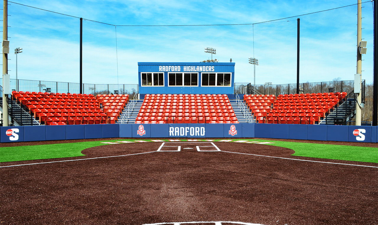 Blue backstop padding printed with Radford behind home plate in front of red stadium seats