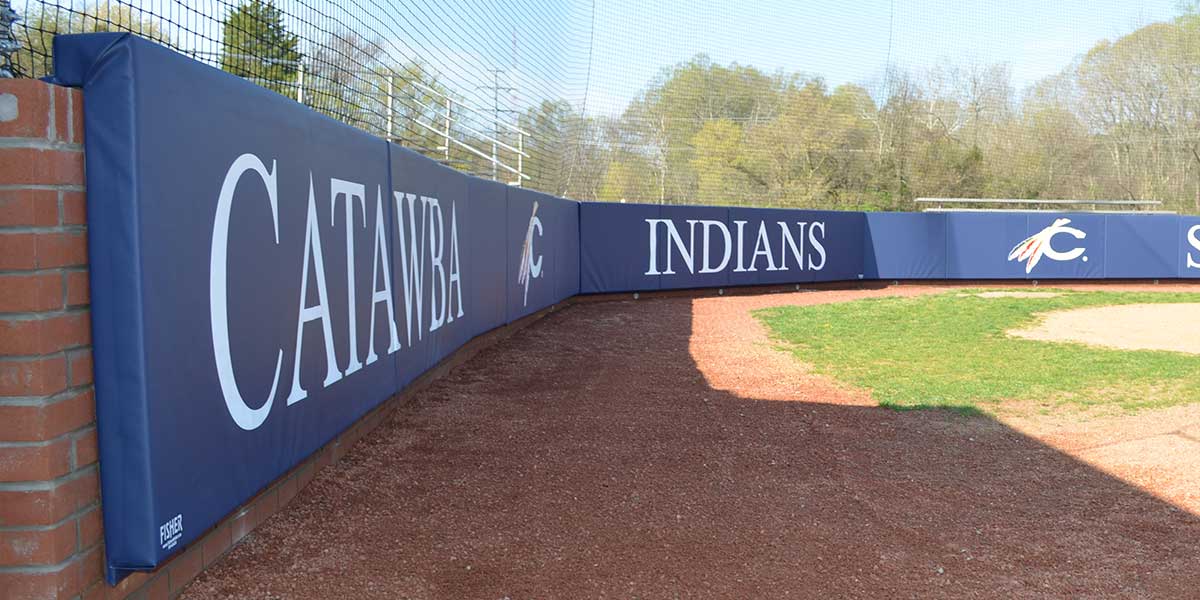 Navy L-shaped padding printed with Catawba Indians wrapping a brick backstop wall